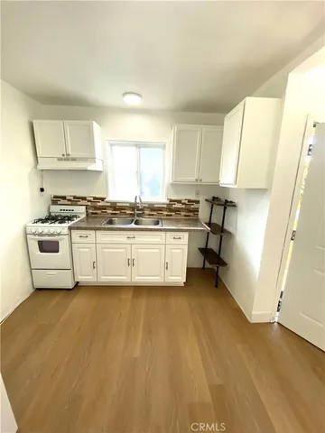 a view of kitchen with a sink a stove and cabinets