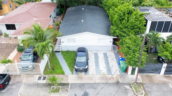 an aerial view of a house with garden space and swimming pool