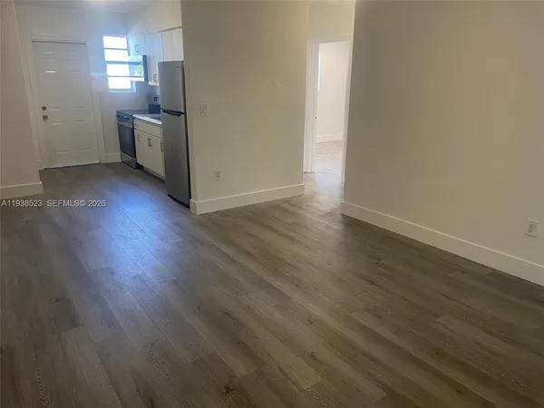 wooden floor in an empty room with a kitchen