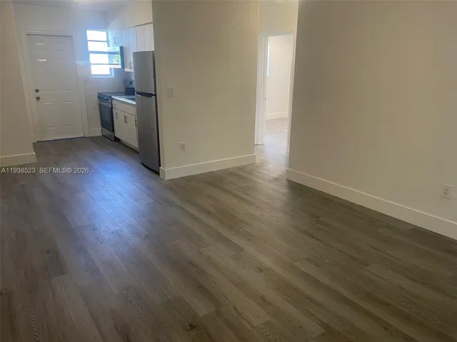 wooden floor in an empty room with a kitchen