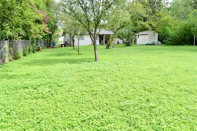 a view of a backyard with large trees