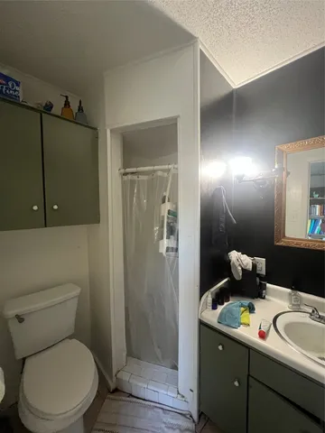 a bathroom with a toilet sink vanity and mirror