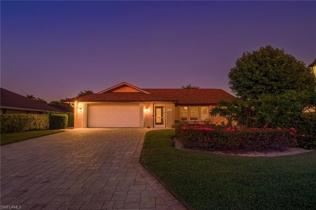 2236 Queens Boulevard Naples, FL 34112 - Photo 3 of 34 a front view of a house with a yard and garage