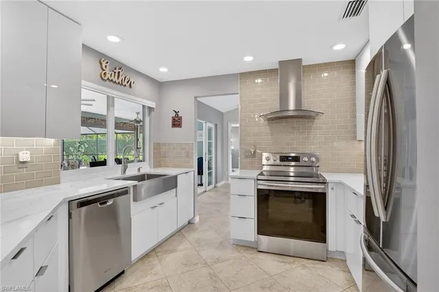 a kitchen with stainless steel appliances granite countertop a stove a sink and a refrigerator