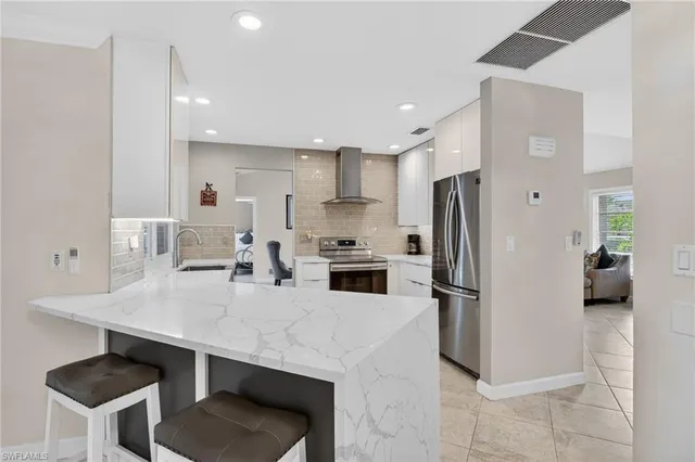 a kitchen with refrigerator and chairs