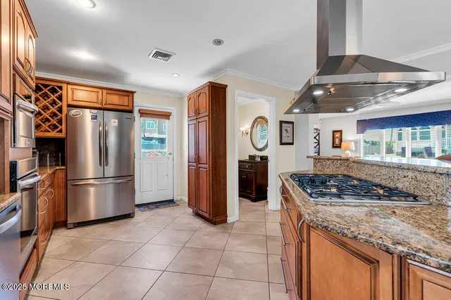 a kitchen with stainless steel appliances granite countertop a refrigerator and a stove top oven