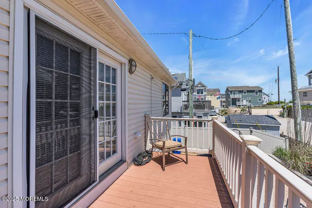 a view of a deck with wooden floor and fence next to a yard