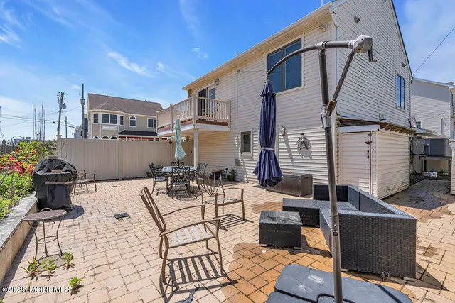 a view of a patio with dining table and chairs with wooden fence