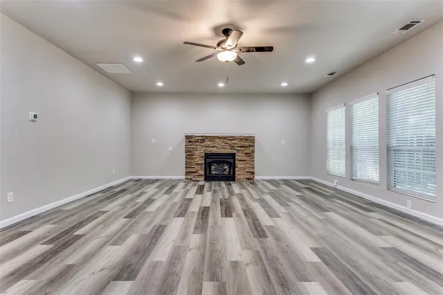 a view of an empty room with a fireplace and a window