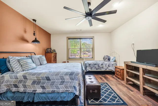 a bedroom with a bed a chandelier and a window