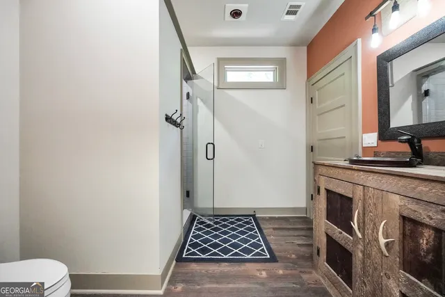 a patio with wooden floor a yard a table and chairs under an umbrella