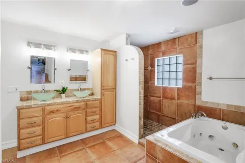 a bathroom with a tub sink and mirror