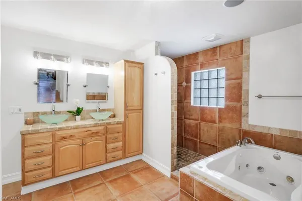 a bathroom with a tub sink and mirror