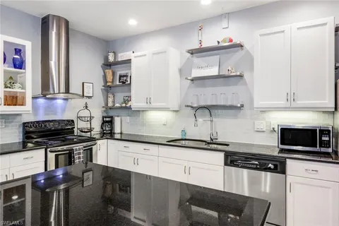 a kitchen with stainless steel appliances granite countertop a sink stove and cabinets