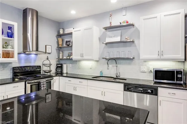a kitchen with stainless steel appliances granite countertop a sink stove and cabinets