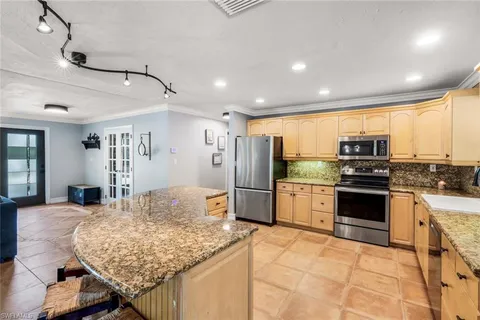 a kitchen with stainless steel appliances granite countertop a stove refrigerator and a sink