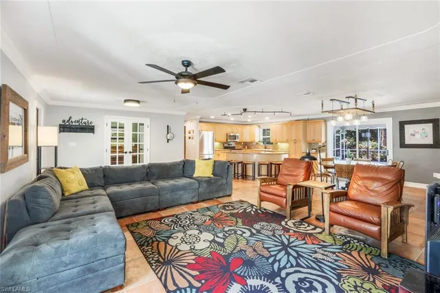 a living room with furniture kitchen view and a large window