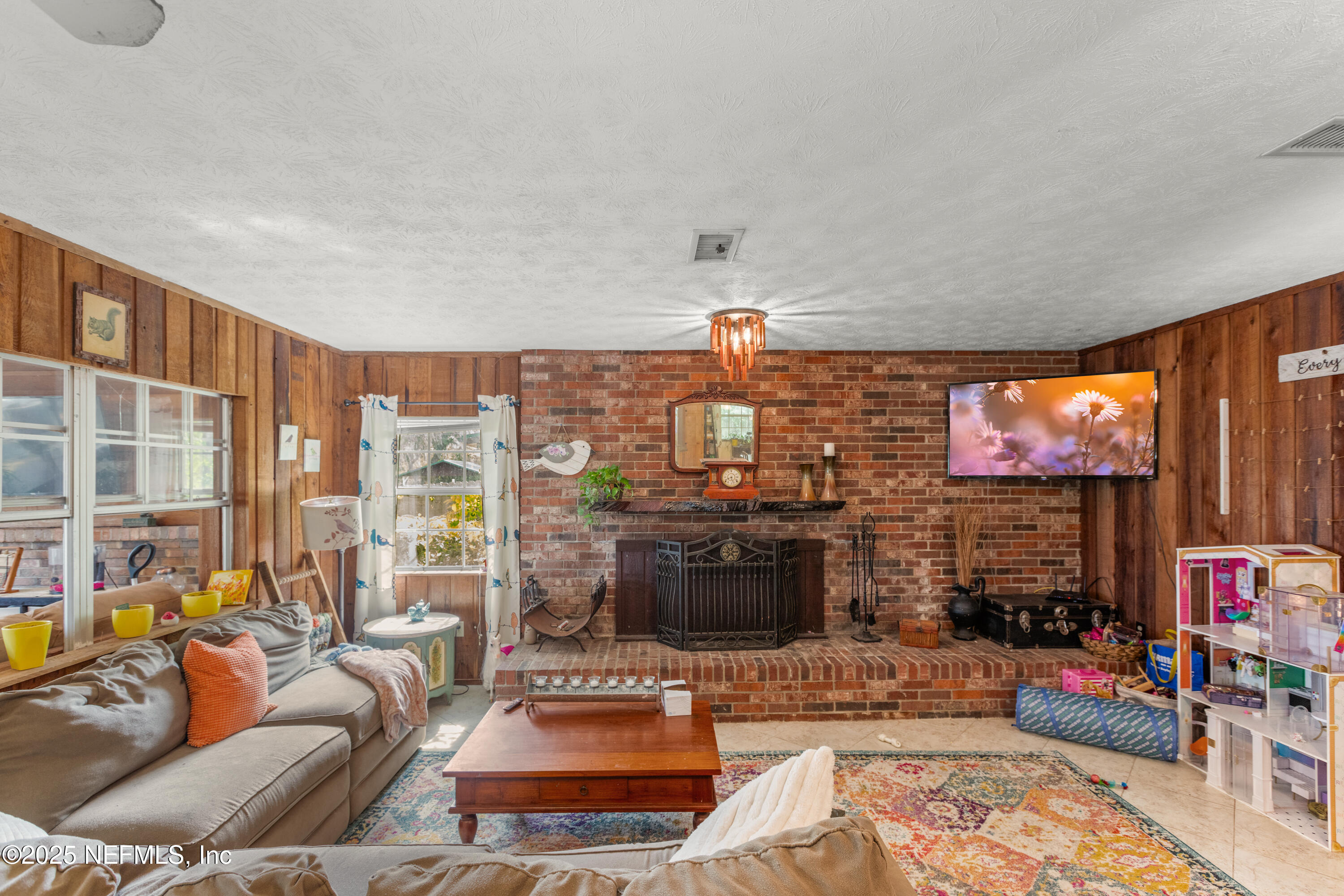 5915 White Sands Road Keystone Heights, FL 32656 - Photo 15 of 47 a living room with furniture a flat screen tv and a floor to ceiling window