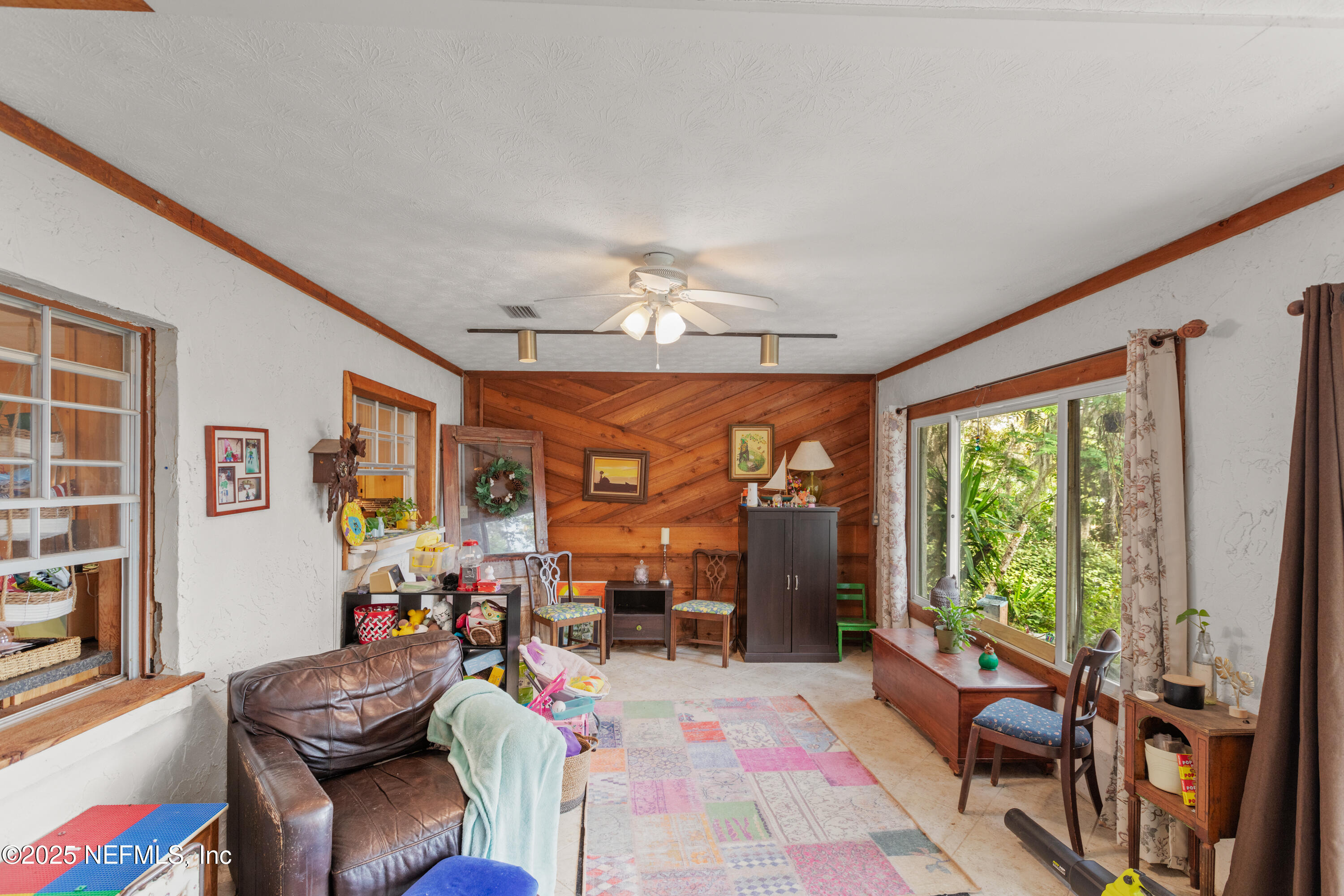 5915 White Sands Road Keystone Heights, FL 32656 - Photo 20 of 47 a living room with furniture a flat screen tv and a floor to ceiling window