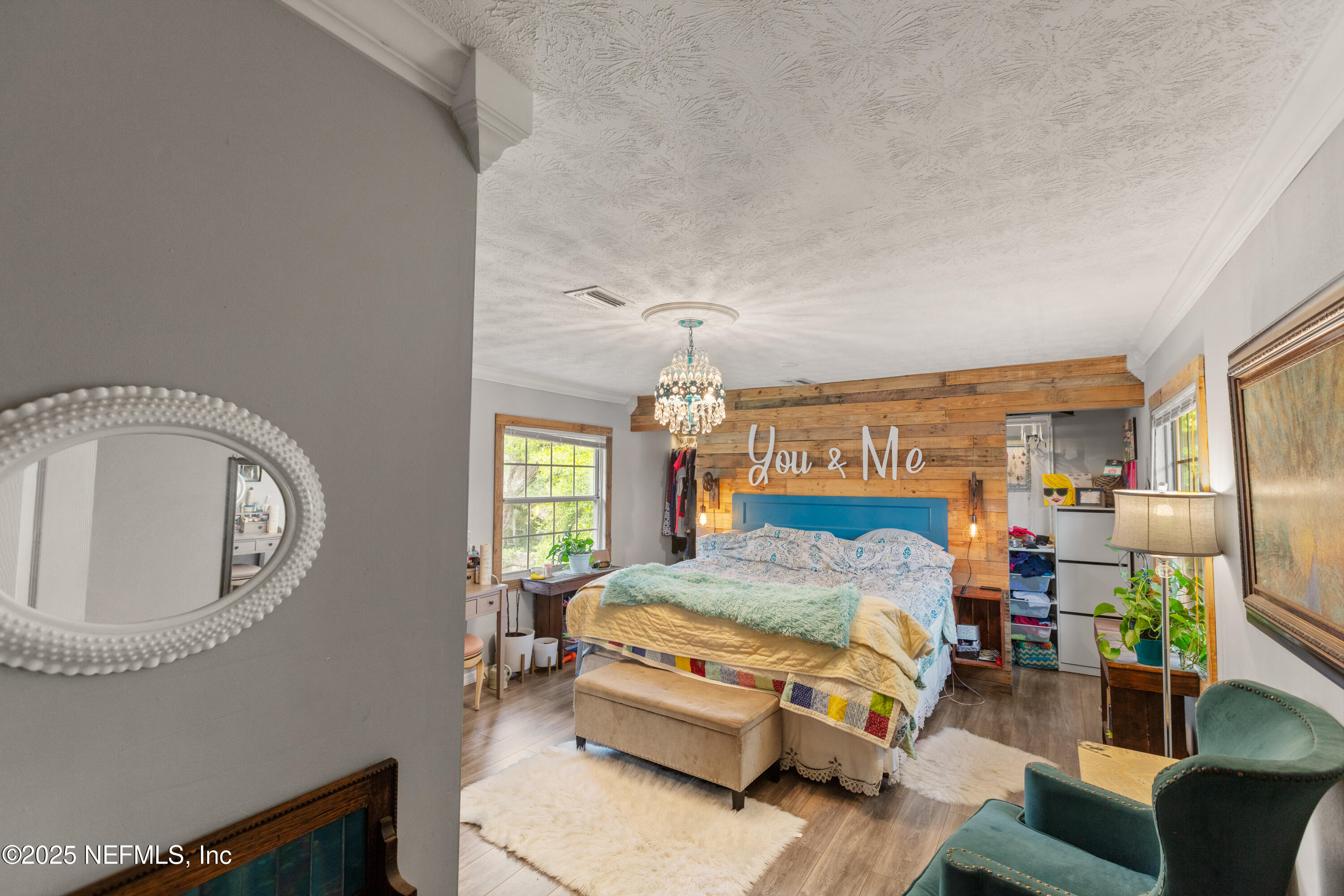 5915 White Sands Road Keystone Heights, FL 32656 - Photo 25 of 47 a bedroom with a bed a mirror and a chandelier