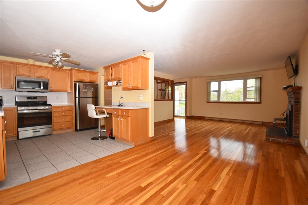 5 Brewster Road Randolph, MA 02368 - Photo 12 of 21 a kitchen with stainless steel appliances kitchen island granite countertop a stove a refrigerator and a view of living room