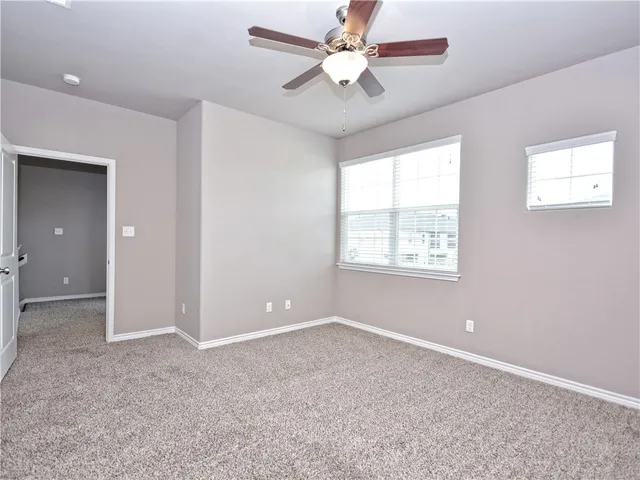 an empty room with fan and windows