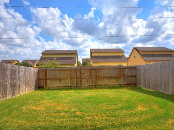 a view of a backyard with wooden fence