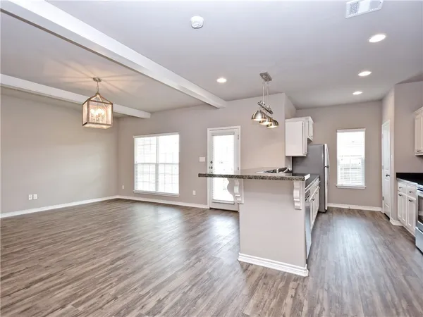 a view of kitchen with sink refrigerator and window