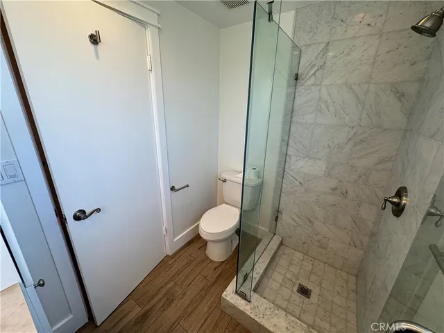a bathroom with a granite countertop shower and a toilet