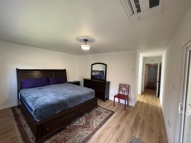 a bedroom with a bed and wooden floor