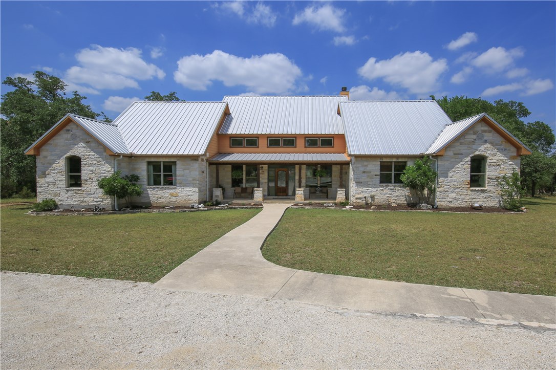 1230 Water Park Road Wimberley, TX 78676 - Photo 1 of 1 a front view of a house with a garden and yard