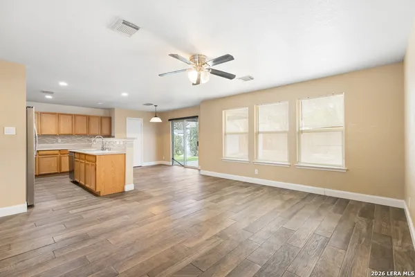 a view of an empty room with a kitchen and a stove top oven