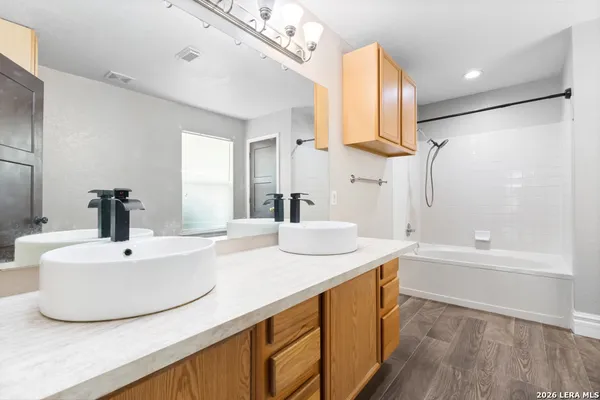 a bathroom with a double vanity sink a mirror and a bathtub