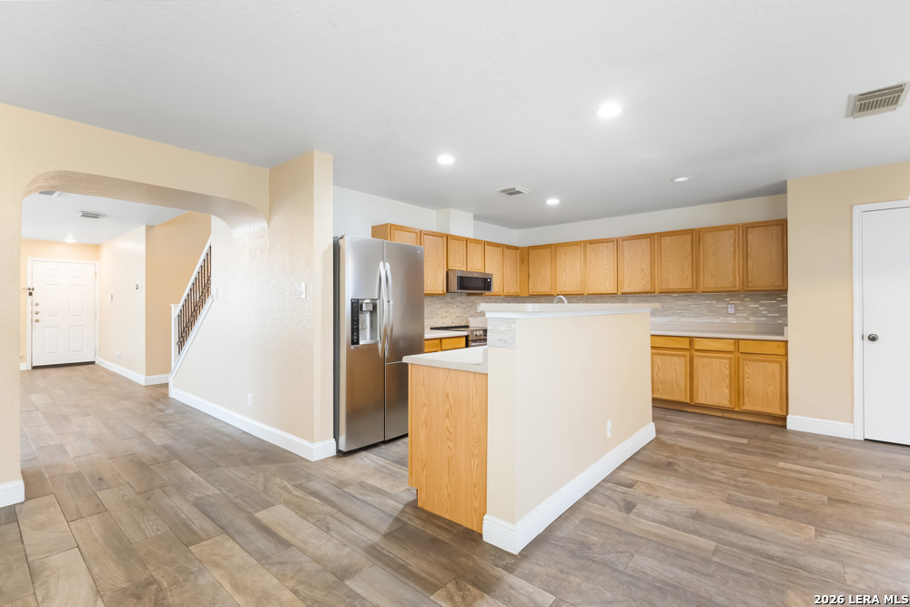 140 Springtree Parkway Cibolo, TX 78108 - Photo 7 of 25 a view of a kitchen with a sink refrigerator and wooden floor