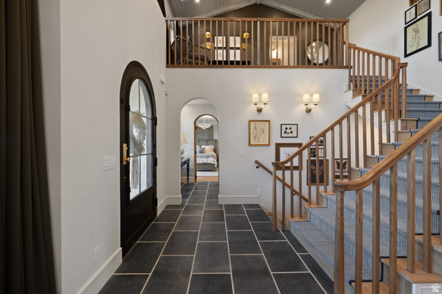 558 West Rheinfalls Circle Midway, UT 84049 - Photo 16 of 61 Foyer featuring large format tile flooring, an arched entry door, and a hardwood staircase with carpet runners
