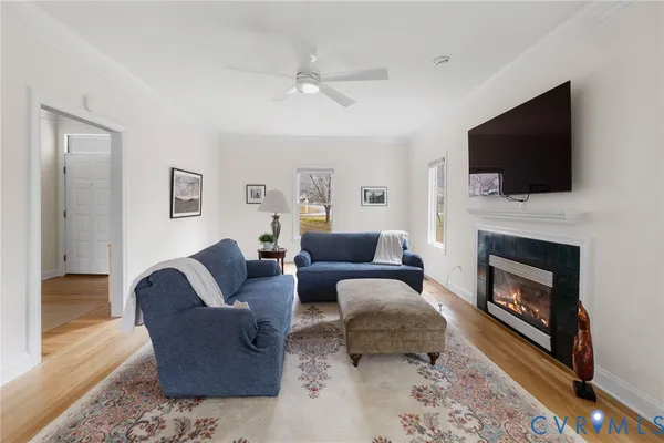 a living room with furniture a flat screen tv and a fireplace