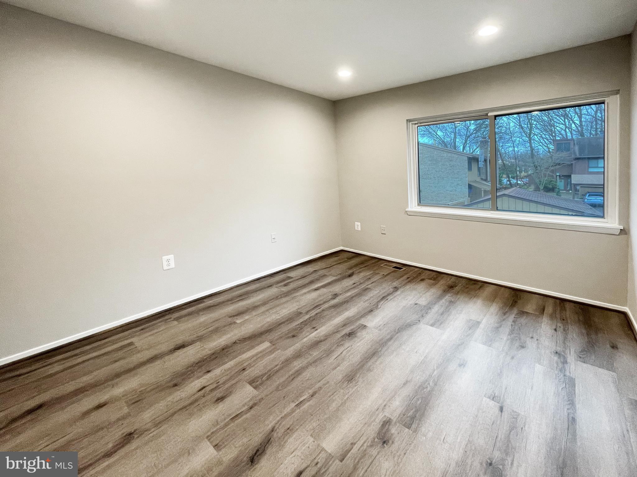 11968 Greywing Court Reston, VA 20191 - Photo 13 of 13 a view of an empty room with wooden floor and a window