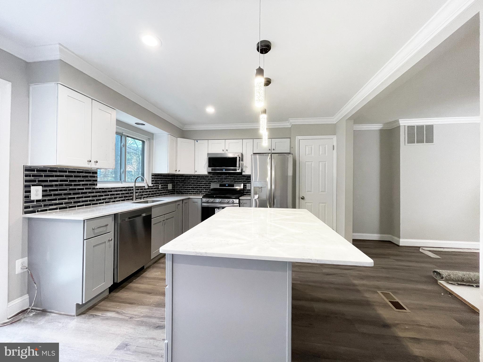11968 Greywing Court Reston, VA 20191 - Photo 2 of 13 a kitchen with kitchen island a sink dishwasher stove and white cabinets