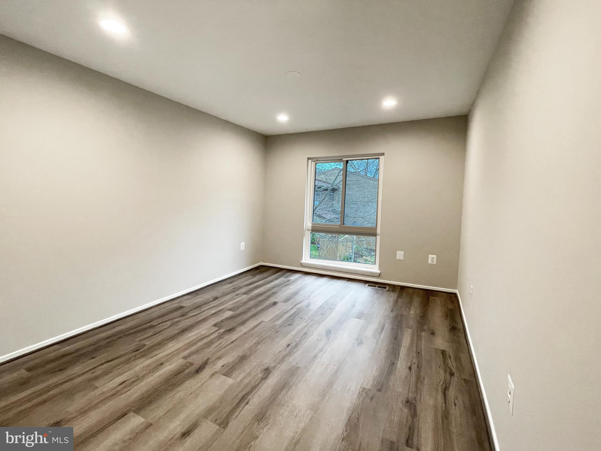 11968 Greywing Court Reston, VA 20191 - Photo 7 of 13 a view of an empty room with wooden floor and a window