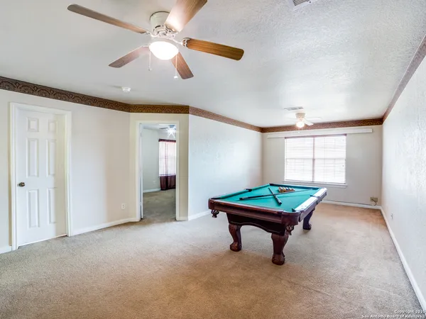 a room with pool table and windows