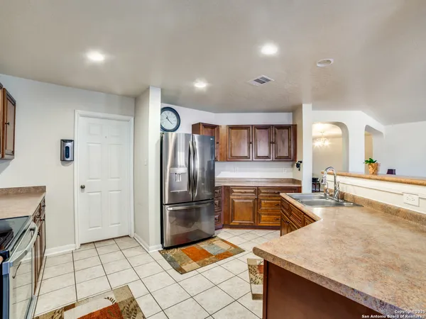 a kitchen with granite countertop a refrigerator and a sink