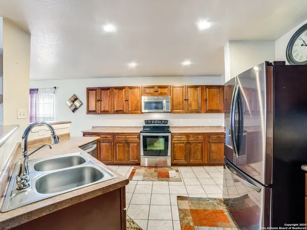 a kitchen with stainless steel appliances granite countertop a sink and a refrigerator