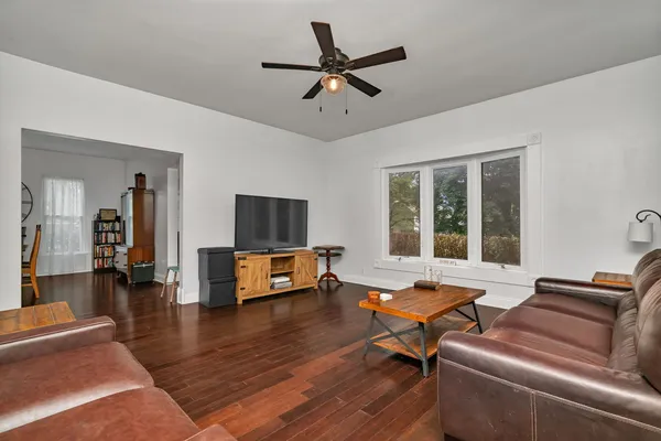 a living room with furniture and a flat screen tv with wooden floor