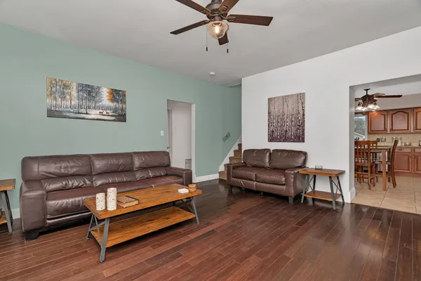 a living room with furniture and a wooden floor