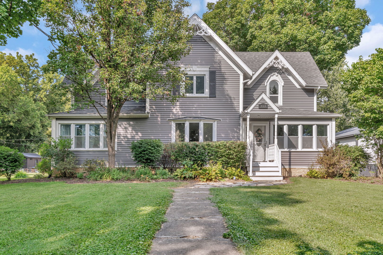 313 East George Street Odell, IL 60460 - Photo 2 of 44 a front view of a house with a garden and trees