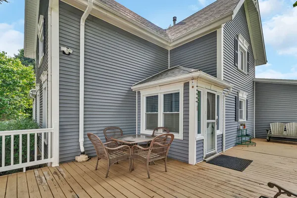 a view of a house with a deck and furniture