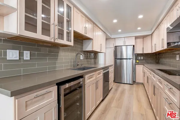 a kitchen with stainless steel appliances a refrigerator a sink a stove and cabinets