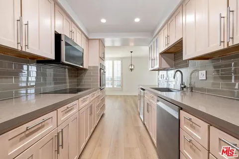 a kitchen with stainless steel appliances a sink stove and cabinets