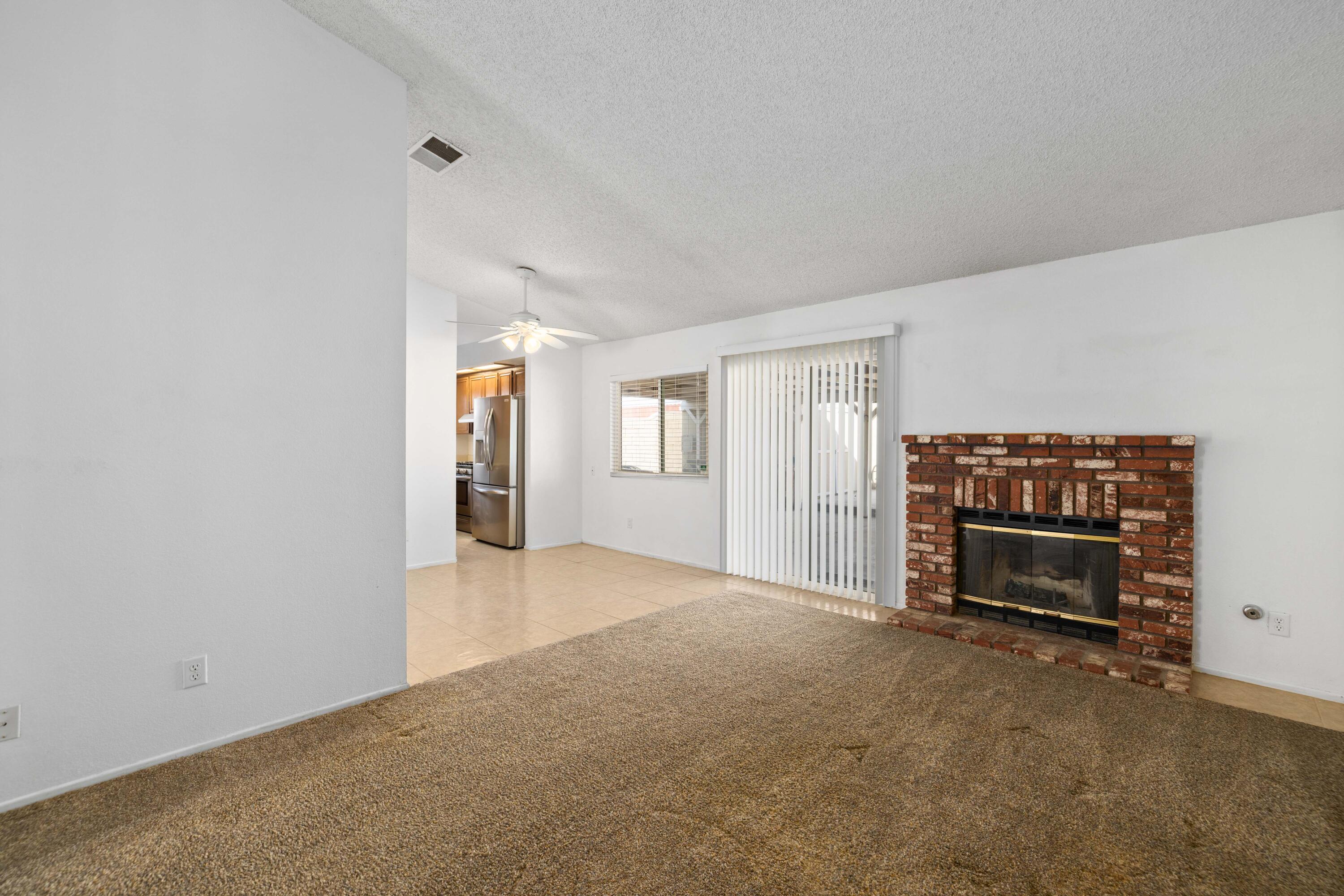3043 Echo Drive Rosamond, CA 93560 - Photo 3 of 24 an empty room with fireplace and cabinet