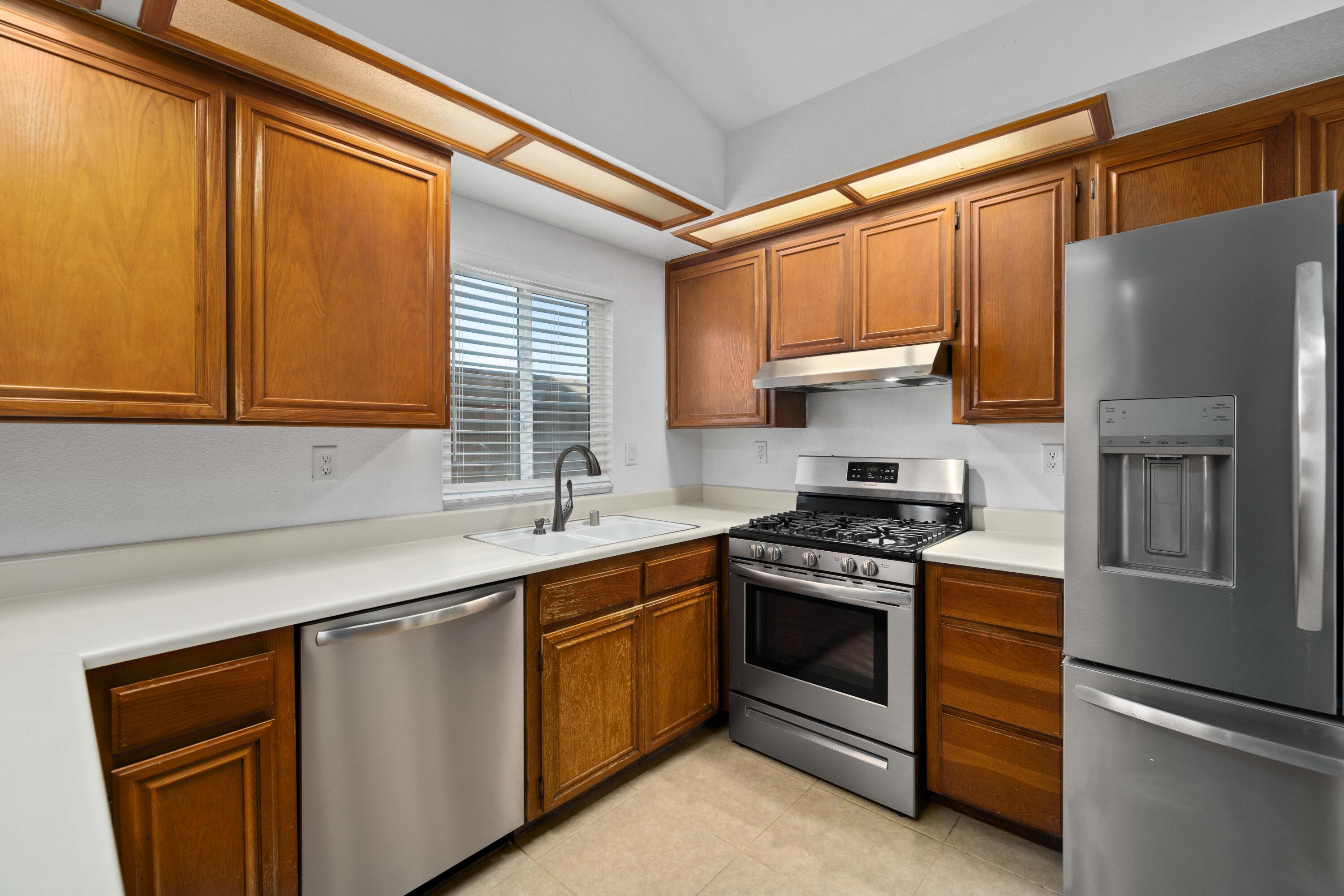 3043 Echo Drive Rosamond, CA 93560 - Photo 6 of 24 a kitchen with a sink stove and refrigerator